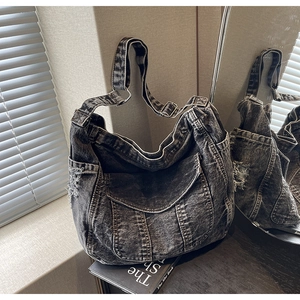 Détail d'un grand sac fourre-tout en denim noir délavé vintage à poches multiples