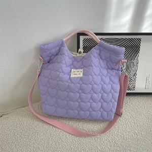 Vue détaillée du sac en toile lilas matelassé en cœur avec bandoulière rose