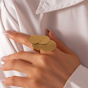 Detail showing gold brushed geometric multi-layer circle ring on model's finger