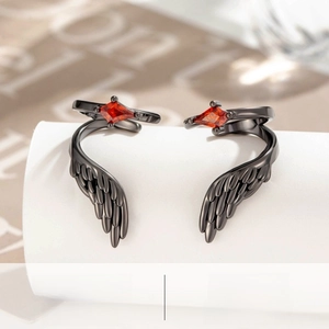 Macro detail of gunmetal wing ear cuffs with a central red rhinestone inlay