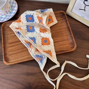 Detailed crochet knit pattern showing orange and blue flowers on a beige headscarf