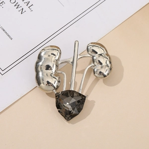 Detailed macro view of silver anatomical kidney brooch with faceted grey gemstone