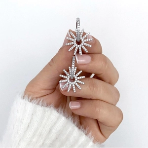 Sparkling s925 silver sunburst earrings with colorful zircon crystals shown in a hand