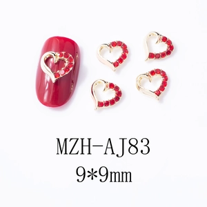 Détail macro de breloques à ongles coeur rouge évidé avec base en alliage doré chic