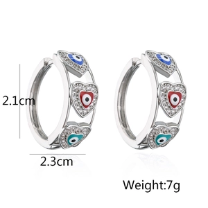 Detail of silver hoop earrings with evil eye heart charms, 2.3cm width and 7g weight