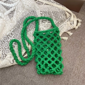 Detail of bright green hand-woven cotton cell phone bag with hollow mesh pattern