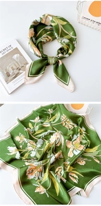 Detailed view of the dark green floral silk scarf showing texture and elegant print