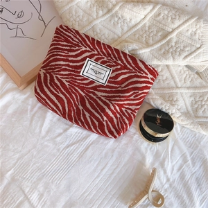Macro detail of red zebra pattern chenille makeup bag with Time to Party label