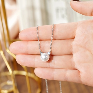 Close-up of a silver cat ear pearl necklace featuring sparkling diamond accents