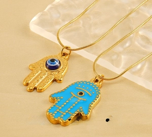 Detailed view of Hamsa Hand pendants with blue Evil Eye and polished gold stainless steel