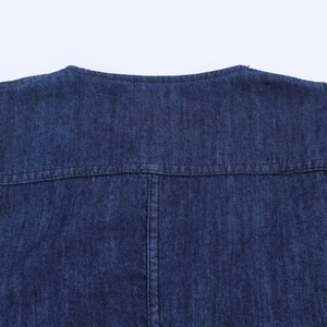 Detailaufnahme des dunkelblauen Jeanskleides mit Doppelnaht und Köperbindungstextur