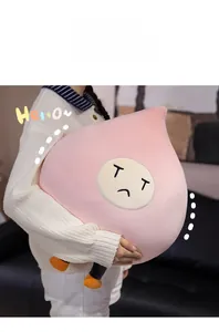 Close-up of soft pink peach plush toy with sad face expression and smooth texture