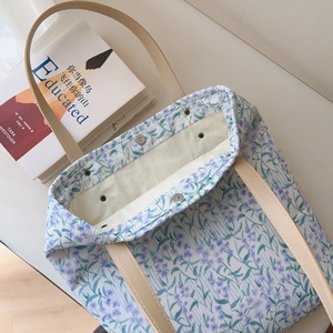 Detail view of floral cotton tote bag with leather handles and magnetic snap closure