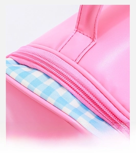 Close-up of pink makeup bag showing durable zipper detail and blue checkered fabric edge
