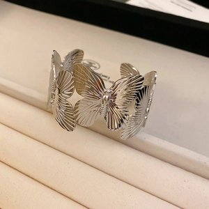 Detailed view of silver butterfly bangle featuring intricate metallic wing textures