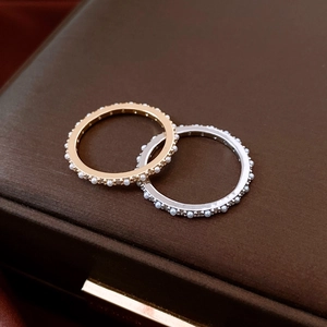 Detalle macro de anillos eternity con perlas y circonitas alternas en oro y plata