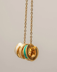 Detailed view of 18K gold plated hoop charms with white and turquoise enamel coatings