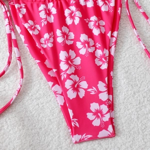 Detail of rose pink bikini bottom with white hibiscus print and side tie-up straps