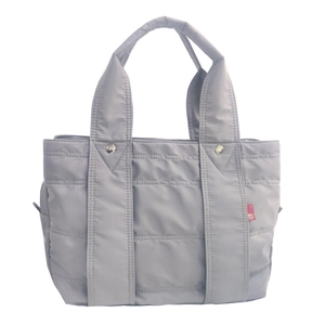 Close-up of grey quilted nylon tote bag with durable double handles and rivet detail