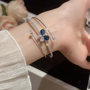 Dettaglio di un bracciale a farfalla in argento con zirconi blu a goccia d'acqua