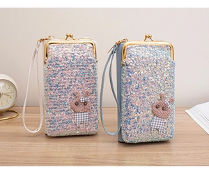 Detail of pink and blue sequin crossbody bags with crochet bunny charms and metal clasps