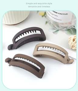 Three matte banana clips in dark brown, medium brown, and beige colors on a white surface