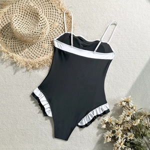 Detail view of one-piece swimsuit with ruffled trim and black and white contrast design