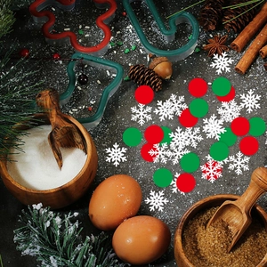 Christmas snowflake and round confetti scattered on a table with festive baking accessories
