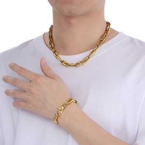 Detailed view of 10mm gold polished link chain necklace and bracelet set on male model