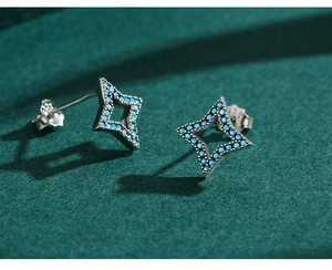 Macro shot of 925 sterling silver star stud earrings with turquoise blue gemstone inlay