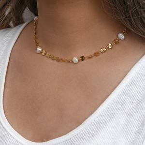 Golden stainless steel necklace featuring sunburst discs and white baroque pearls