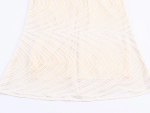 Macro shot of wavy sequin embroidery detail on beige sleeveless dress hem