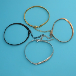 Detailed view of flat snake chains in gold, rose gold, silver, and black with lobster clasps