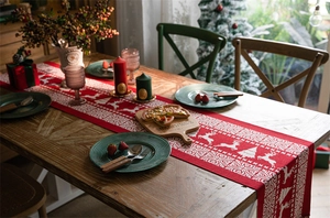 Close-up of red Christmas table runner with white reindeer and snowflake jacquard patterns