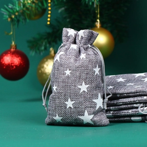 Grauer Weihnachtsbeutel aus Leinen mit weißen Sternen und Kordelzug vor Festtagsdekor