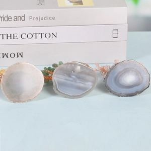 Three natural agate slice bases with unique textures and colors on a light desk