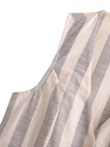 Détail de la texture en lin mélangé à rayures grises avec un petit bouton blanc sur le vêtement