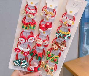 Close-up of festive red Christmas hair ties with resin Santa and reindeer charms