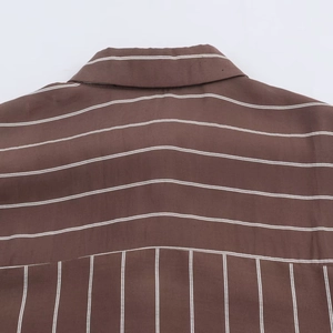Detail of vertical and horizontal stripes on the back collar of a brown striped shirt