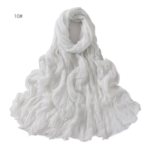Detail shot of white linen-blend scarf with breathable crinkle texture and soft pleats
