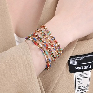 Rainbow enamel cuban link bracelet set in gold finish worn on wrist with a blazer