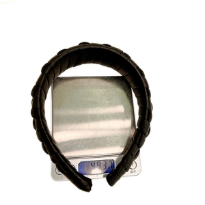 Solid black braided headband for women weighing 49.3g on a digital scale