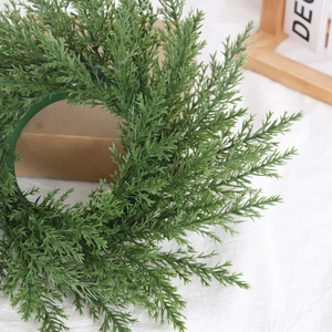 Détail d'une couronne de cyprès artificiel vert pour décoration murale festive de Noël