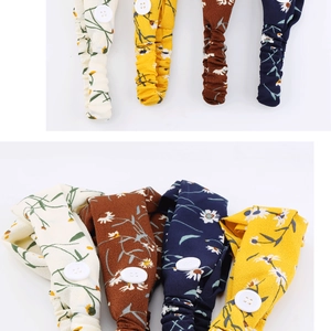 Detail of floral chiffon headbands with side buttons and elastic bands in four colors