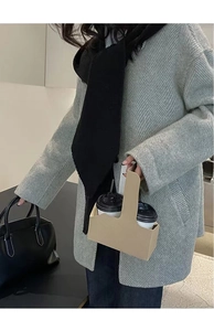 Eco-friendly brown kraft paper coffee cup carrier for two cups held by a person