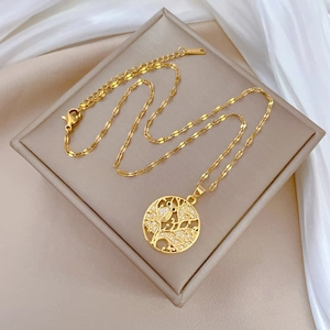 Macro detail of gold tree of life owl pendant with white crystals on silk jewelry box