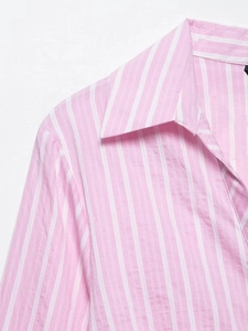 Close-up of pink and white striped shirt collar and fabric texture on a V-neck dress