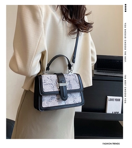 Rear view of a model wearing a printed shoulder bag with silver metallic buckle detail