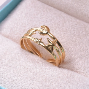 Macro shot of gold moon and star open ring inside a soft pink velvet jewelry box