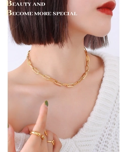 Detail of 18K gold-plated paperclip chain necklace and geometric ring set on model